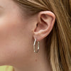 Silver tone hoop earring with polished interior and polished beads 