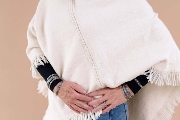 Close up of white poncho with fringe 