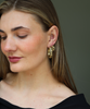 Woman wearing gold hoop earrings against a neutral background