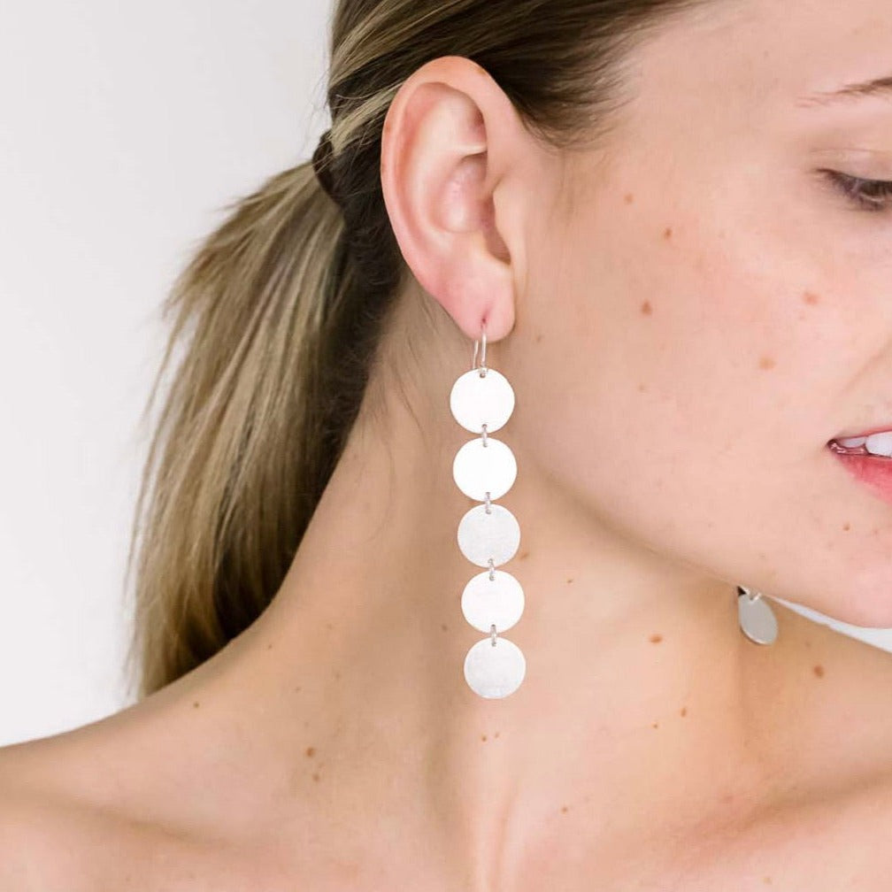 long silver dangle earring on model