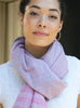 close up of light pink cotton scarf worn at the neck.  scarf has details of light blue in the contrasting weave. 