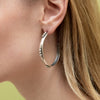 Sterling silver earring with curved overall design. 3mm bead details in groups of three. Overall diameter 1.6 inches