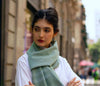 close up of model wearing light green blue scarf at neck